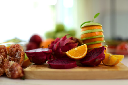 Orange, half of orange, orange lobule and basket with oranges on the wooden table on the green blurred background.Composition with variety of fruits.dieting concept,の写真素材