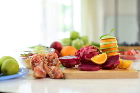 Orange, half of orange, orange lobule and basket with oranges on the wooden table on the green blurred background.Composition with variety of fruits.dieting concept,の写真素材