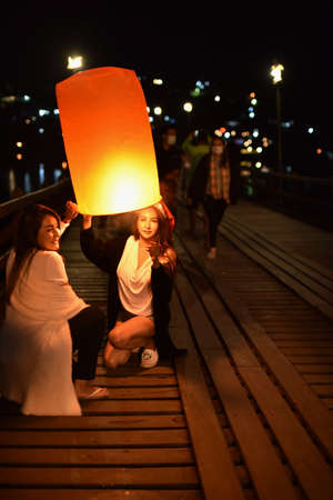 Asian couple with paper lanterns in the night on the bridge.の写真素材