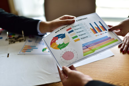 Business people discussing the charts and graphs showing the results of their successful teamwork