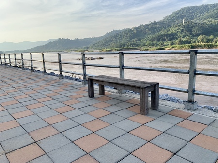 A wooden seat near riverの写真素材