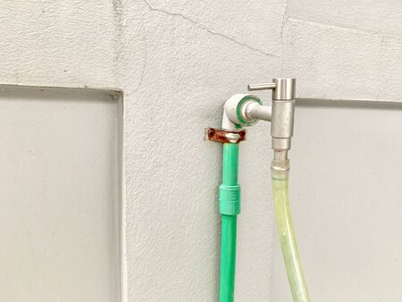 Stainless steel faucet with rubber hose for watering plants Installed in the houseの写真素材