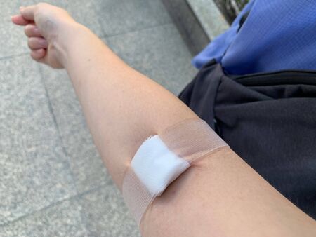white gauze closed on arm, blood donation