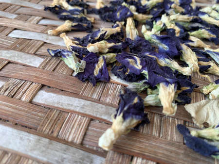fresh and dried butterfly pea flowers on a bamboo trayの写真素材
