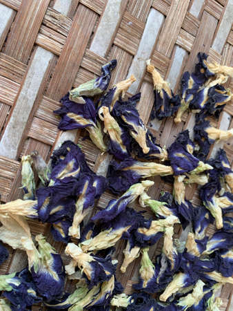 fresh and dried butterfly pea flowers on a bamboo trayの写真素材