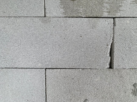Background texture of a gray brick wall with a crack in the middle