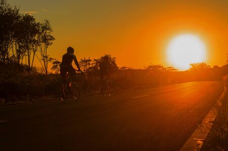 silhouette of a cyclist with sunny before sunsetの写真素材
