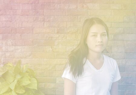 Asian teenager girl standing beside the wall, soft focus with pastel style.の写真素材