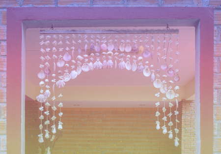 Window curtain decorated suspend with seashell mobile many types, shallow focus and pastel style.の写真素材