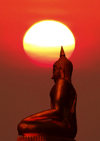 Silhouette of buddha statue with blurred sunrise background.の写真素材