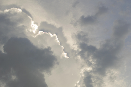 Blurred dramatic sky which has edge of rainbow behind cloudy.の写真素材