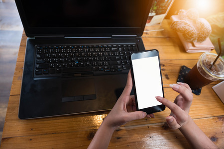 Cropped shot view of woman's hands holding smart phone with blank copy space screen for your text...
