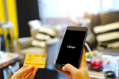 BANGKOK,THAILAND - JAN 3,2020 : A woman hand holding Uber app showing on phone and pay money with credit cardのeditorial素材