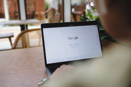 Bangkok. Thailand. APR 24,2021 :A woman is typing on Google search engine from a laptop. Google is the biggest Internet search engine in the world.のeditorial素材