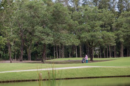 Woman pulling caddies across the golf course.のeditorial素材