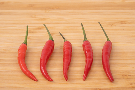 Close up red hot chilli pepper on wood chopping board.の写真素材