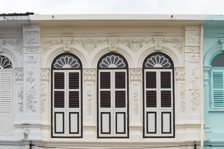Bright vintage Sino-Portuguese Architecture of many the buildings in Phuket town. These old buildings have been constructed more than hundred years and this architectural style is European mixed with Chinese modern. Phuket, Thailand. Ancient window.の写真素材