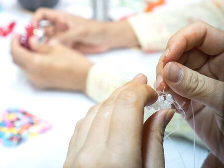 Woman's hand Working hand made weave bead Into various shapes.の写真素材
