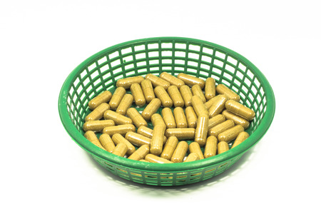 Medicine capsule in a basket isolated on white backgroundの写真素材