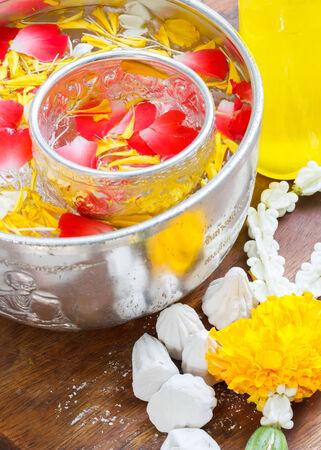 Water in bowl mixed with perfume and vivid flowers corolla , Songkran festival in Thailandの写真素材