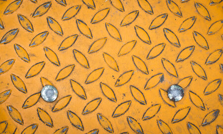 Background of old metal diamond plate in yellow colorの写真素材