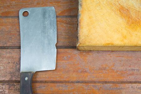 cutting board and old meat cleaver on wooden backgroundの写真素材