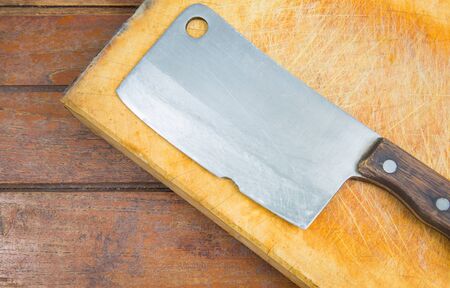 cutting board and old meat cleaver on wooden backgroundの写真素材