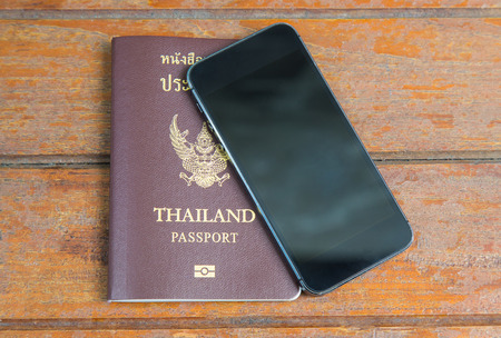 Passport and Mobile phone on wooden backgroundの写真素材