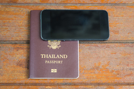 Passport and Mobile phone on wooden backgroundの写真素材