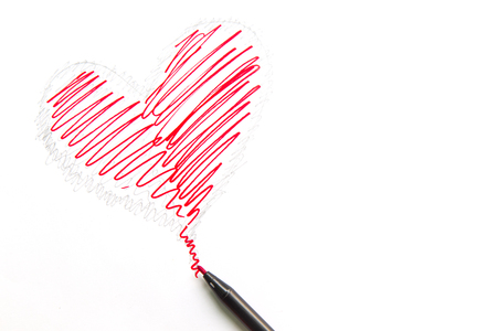 Drawing heart shape with pen isolated on white background.の写真素材