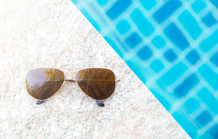 Sunglasses with natural light on poolside.