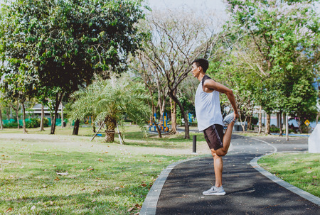 Young man stretching bodies, warming up for jogging.の写真素材