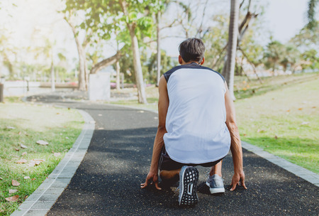 Man preparing to run in park.