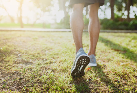 Feet of an athlete running on a park pathway training for fitness and healthy lifestyle.の写真素材