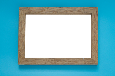 Blank wooden photo frame on blue background.
