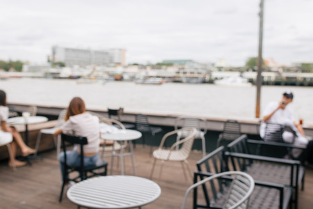 Abstract blurred cafe and river with people for background.
