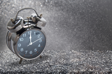 12 o'clock alarm clock on granite table with abstract background.の写真素材