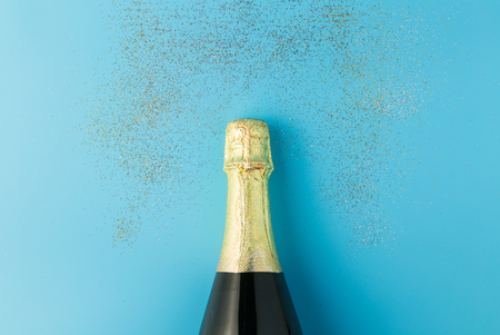 Flat lay of celebration, Champagne bottle on blue background with glitter.の写真素材