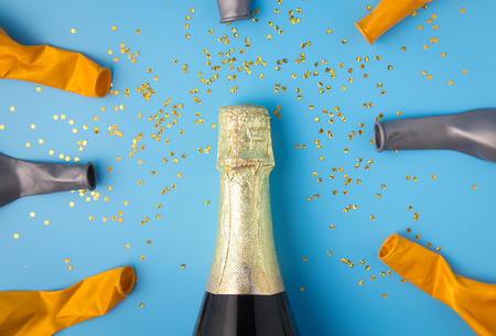 Flat lay of celebration, Champagne bottle and balloon on blue background with glitter.の写真素材