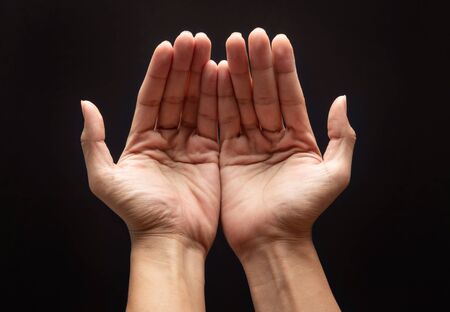 Praying hands in the dark background with faith in religion and belief in God.