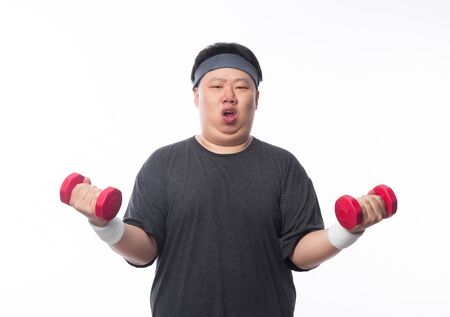 Asian Funny Fat Man in sport outfits exercising with dumbbells and looking to camera isolated on white background.の写真素材
