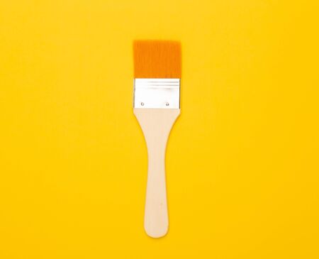 Paintbrush isolated on yellow background.