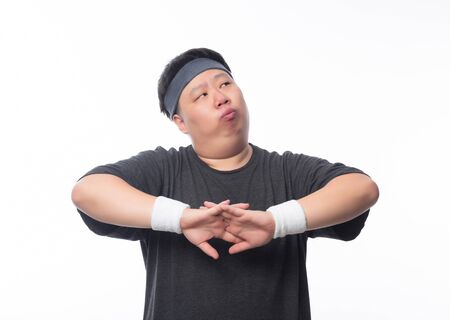Asian funny fat man in sport outfits make streching before workout and looking to copyspace isolated on white background.の写真素材