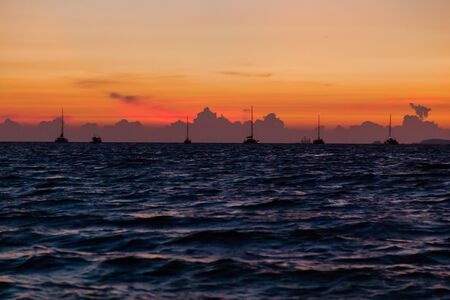 Sea surface with boats at sunset view from a beach in Lipe Islands, Thailand. Summer vacation...