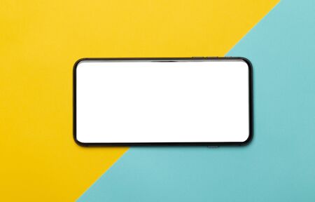 Black smartphone with blank screen mockup isolated on yellow and blue background. Clipping path.