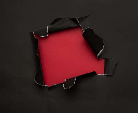 Black torn paper on red background. Black Friday campaign.の写真素材
