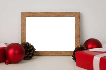 Blank wooden photo frame mockup template and christmas decoration on red blackground.