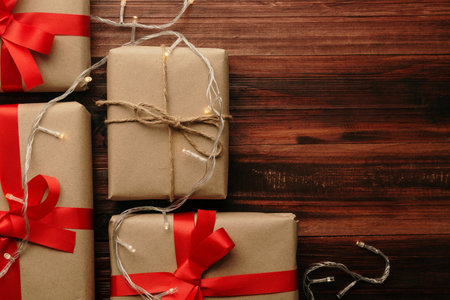 Christmas and new year with gift boxes and string light decoration on wooden table background top view with copy space.の写真素材