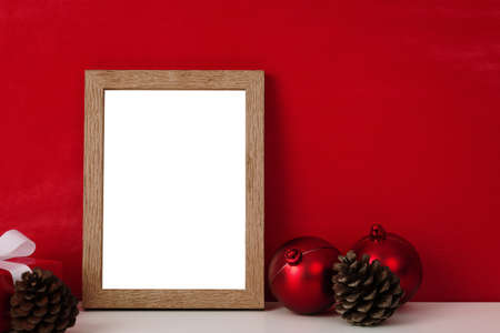 Blank wooden photo frame mockup template and christmas decoration on red blackground.の写真素材