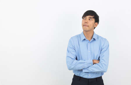 Young handsome asian business man thinking an idea while looking up isolated on white background.の写真素材